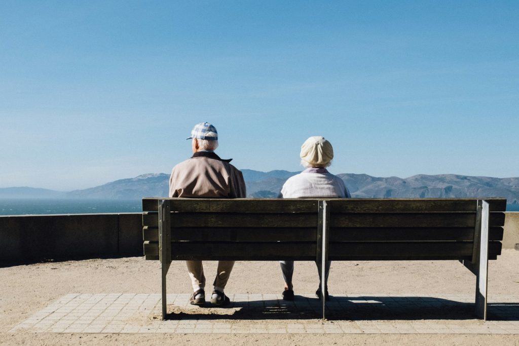 Couple de retraités assis sur un banc face à la mer
