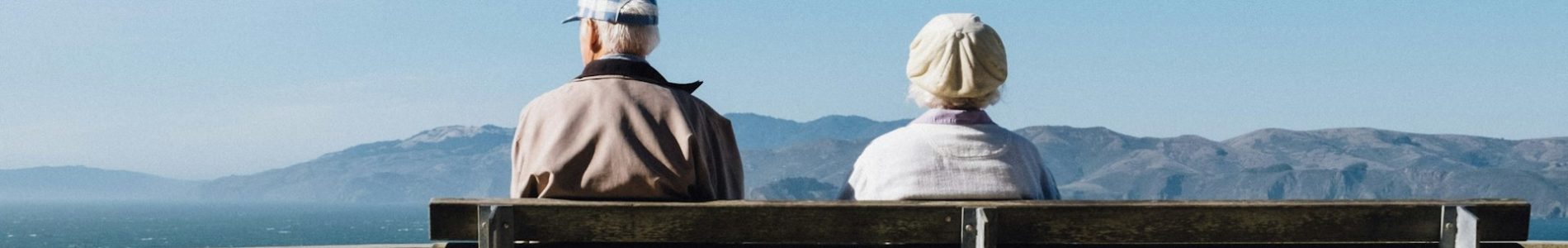 Couple de retraités assis sur un banc face à la mer