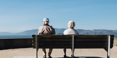 Couple de retraités assis sur un banc face à la mer